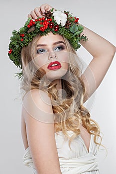 Glamorous blonde woman portrait. Fashion female model with blond curly hairstyle, make-up and green and red winter accessories