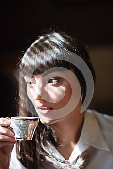 Glamorous brunette holding teacup