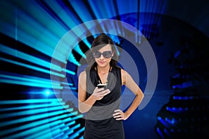 Glamorous brunette using smartphone against blue technology background