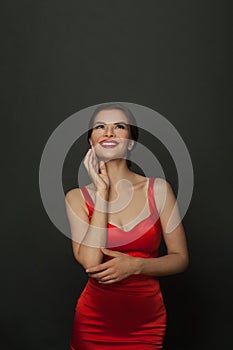 Glamorous brunette woman looking up on black background