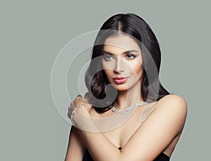 Glamorous brunette woman with makeup, long hair and diamond necklace and bracelet