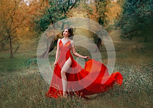 Glamorous brunette woman in red scarlett dress very high sexy slit on her leg.