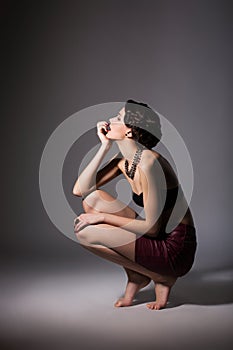 Glamorous Enticing Discalced Woman Sitting on her Hunkers in Reverie. Daydream photo