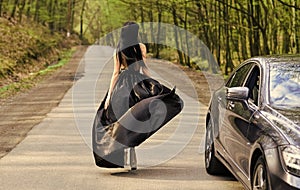 Glamorous girl and luxury car. Escort and sexual services. Driver girl. Beauty and fashion. Woman in black dress