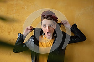 Glamorous lady in punk rock style party clothes with dark pink hair in casual dress, black leather jacket, and long