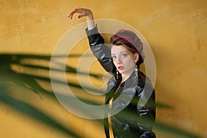 Glamorous lady in punk rock style party clothes with dark pink hair in casual dress, black leather jacket, and long