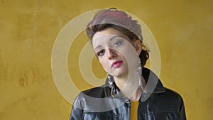 Glamorous lady in punk rock style party clothes with dark pink hair in casual dress, black leather jacket, and long