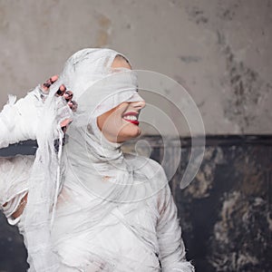 Glamorous mummy. Portrait of a young beautiful woman in bandages all over her body.