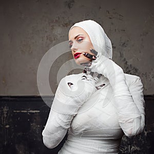 Glamorous mummy. Portrait of a young beautiful woman in bandages all over her body.