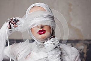 Glamorous mummy. Portrait of a young beautiful woman in bandages all over her body.