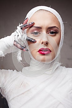 Glamorous mummy. Portrait of a young beautiful woman in bandages all over her body.