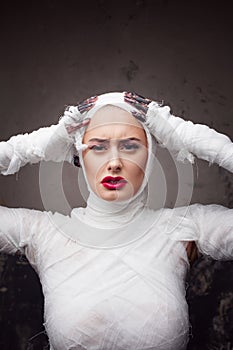 Glamorous mummy. Portrait of a young beautiful woman in bandages all over her body.