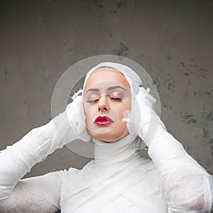 Glamorous mummy. Portrait of a young beautiful woman in bandages all over her body.