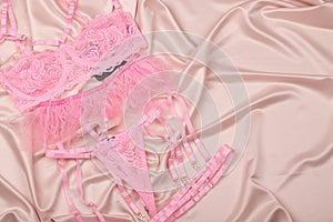 Glamorous stylish sexy lace lingerie on a satin background. Women`s bra, panties, erotic clothes