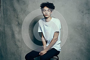 glamorous teenager in pants and t-shirt curly hair fabric backdrop photocall studio