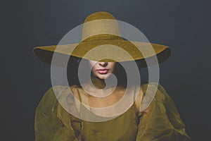 Glamorous woman brunette wearing wide broad brim hat on black background