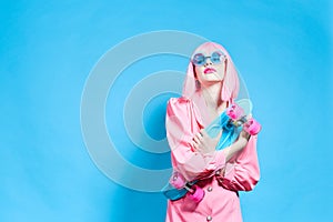 glamorous woman in sunglasses wears a pink wig isolated background