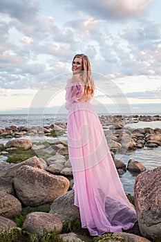 Glamorous young woman in pink dress outdoor