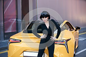 Glamour brunette babe standing near luxury sport car