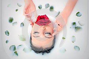 Glamour closeup portrait in milk bath with and leaves rose petals.