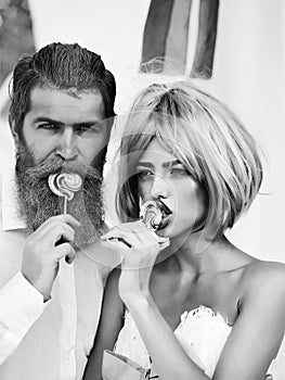 Glamour couple eating lollipop