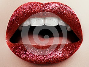 Glamour fashion bright red lips make-up with glitter. Macro of woman`s face part. Sexy glossy lip makeup, luxury lady