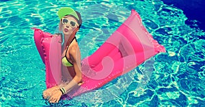 Glamour girl with inflatable mattress in the pool hot summer par