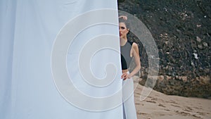 Glamour girl resting beach shore. Professional fashion model looking camera