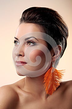 Glamour and gorgeous brunette with feather earring