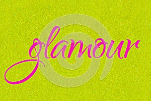 Glamour lettering word neon pink on golden lime glitter texture. Shiny sparkle background