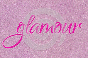 Glamour lettering word neon pink on light pink ballet slipper glitter texture. Shiny sparkle background