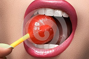 Glamour macro shoot with woman's lips with a sweet bonbon lollipop