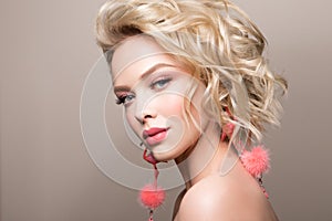 Glamour portrait of beautiful girl model with makeup and romantic wavy hairstyle.