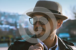 Glamour portrait of beauty man in hat and glasses looking away o