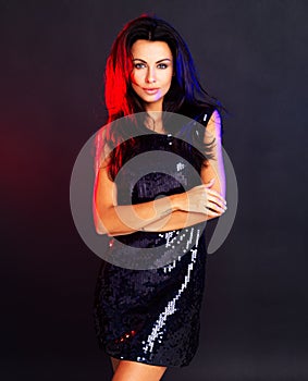 Glamour, style and a confident woman looking cool in an evening dress against a dark, black background. Proud female