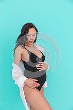 Glamour and style of young pregnant woman with blue material on the blue background