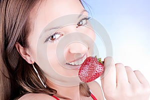 Glamour woman eating fresh strawberry