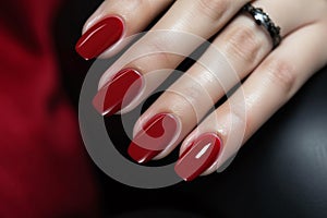 Glamour woman hand with classic red nail polish on her fingernails. Red nail manicure with gel polish at luxury beauty salon. Nail