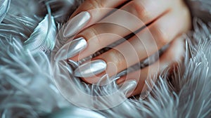 Glamour woman hand with luxury silver color nail polish manicure on fingers, touching silver feathers