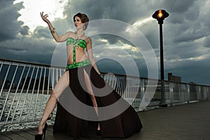 Glamour young woman on the pier wearing designers swimsuit resort floating dress.