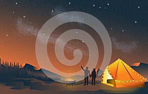 Glamping couple Stargazing looking at dark night sky stars by fire pit