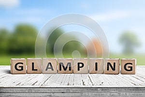 Glamping sign on wooden planks in the summer photo