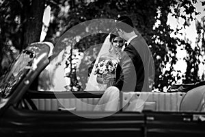 Glance of the bride with a bouquet next to the groom