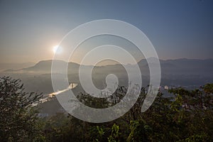 Glaring sunrise over Luang Prabang mountains, river