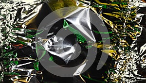 Glaring surface. Crumpled aluminum foil. Crinkled background. Colored sparkle