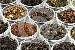 Glas bowls with a variaton of different dried tea leaves close up full frame photo
