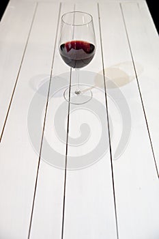 GLAS OF WINE ON WHITE WOODEN TABLE