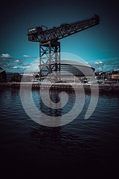 Glasgow Scotland June 2021 Glasgow finnieston crane reflection in water with blue skies on summer day