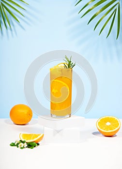 Glass of 100% Orange juice with orange slices fruits on pastel color background. Summer sea vacation and travel concept.