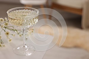 Glass of alcohol drink on table in room, closeup and space for text. Relax at home